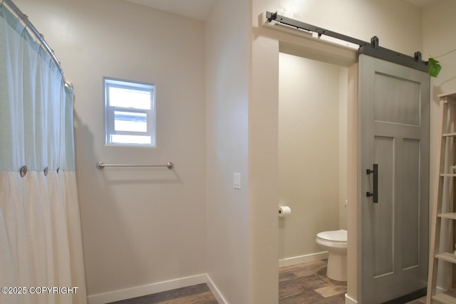 bathroom with hardwood / wood-style floors and toilet