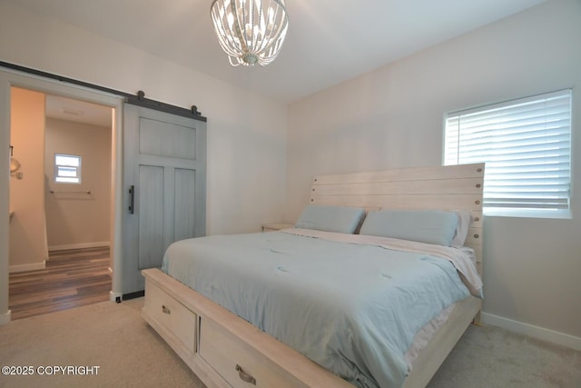 bedroom with a barn door, light colored carpet, and a chandelier