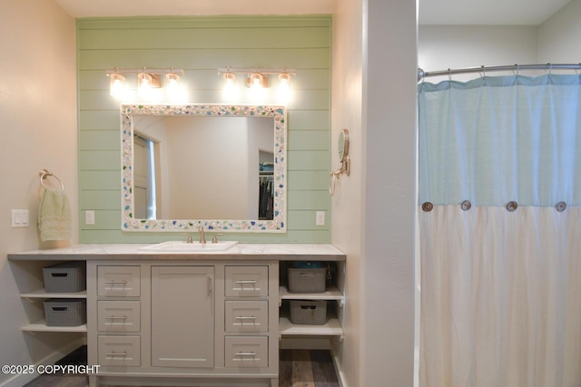 bathroom featuring vanity, a shower with shower curtain, and wood walls