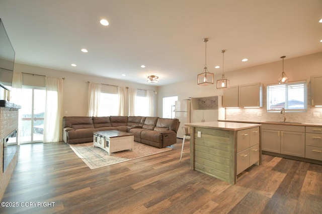 kitchen with a kitchen island, sink, dark hardwood / wood-style flooring, hanging light fixtures, and white refrigerator