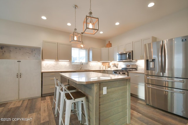 kitchen with white cabinetry, decorative light fixtures, a kitchen island, stainless steel appliances, and backsplash