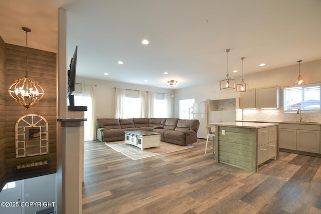 kitchen with pendant lighting, sink, a breakfast bar area, white fridge, and a center island