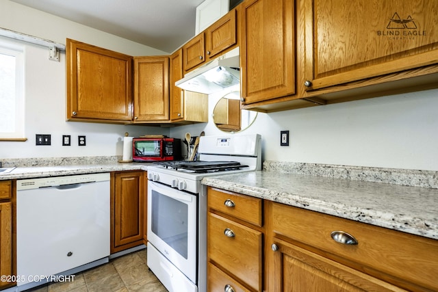 6976 W Windsor Dr, Wasilla, AK 99623 - kitchen featuring white appliances, under cabinet range hood, brown cabinetry, and light stone counters