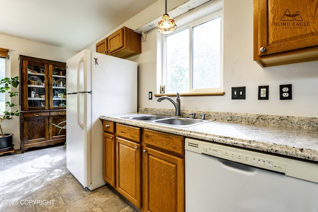 6976 W Windsor Dr, Wasilla, AK 99623 - kitchen with white appliances, brown cabinets, decorative light fixtures, and light stone finish flooring