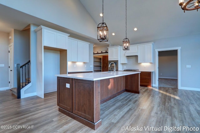 kitchen featuring white cabinetry, light hardwood / wood-style flooring, pendant lighting, and a spacious island