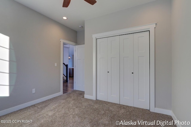 unfurnished bedroom with carpet flooring, ceiling fan, and a closet