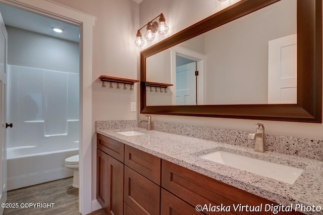 full bathroom featuring vanity, wood-type flooring, shower / tub combination, and toilet