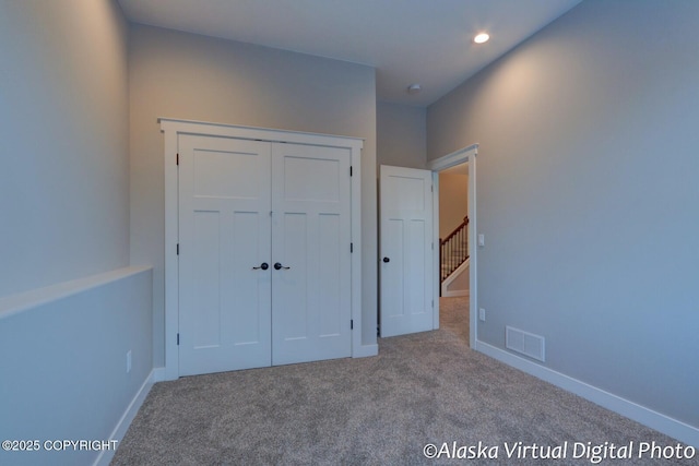 unfurnished bedroom featuring carpet flooring and a closet