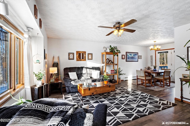 living room with a baseboard heating unit, ceiling fan with notable chandelier, dark hardwood / wood-style floors, and a textured ceiling