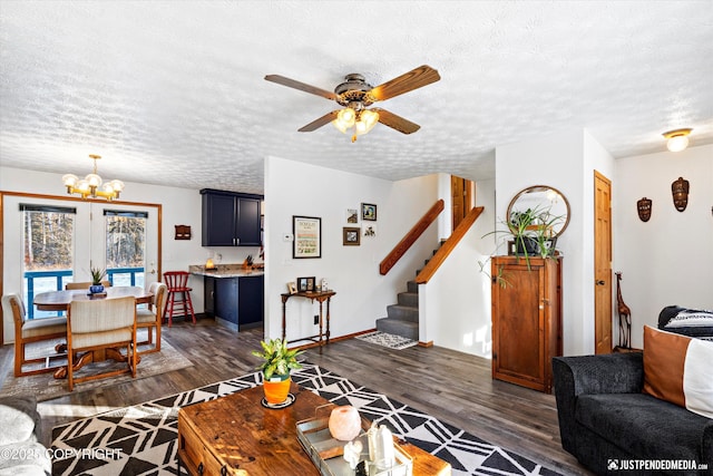 living room with dark hardwood / wood-style flooring, ceiling fan with notable chandelier, and a textured ceiling