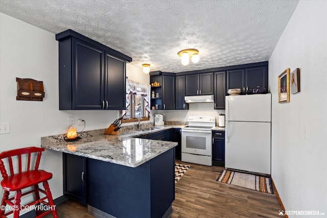 kitchen featuring sink, kitchen peninsula, light stone countertops, dark wood-type flooring, and white appliances