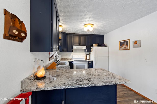 kitchen with sink, light stone counters, white appliances, and kitchen peninsula