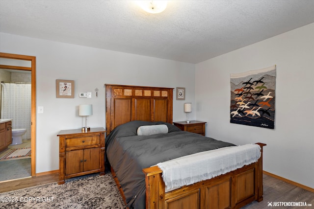 bedroom featuring a textured ceiling, light hardwood / wood-style floors, and ensuite bath