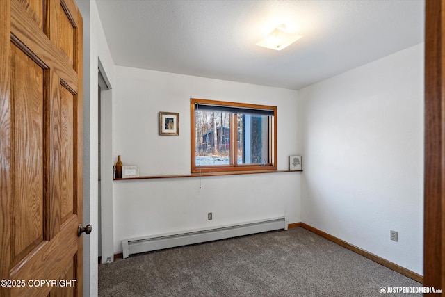 empty room featuring dark carpet and a baseboard radiator