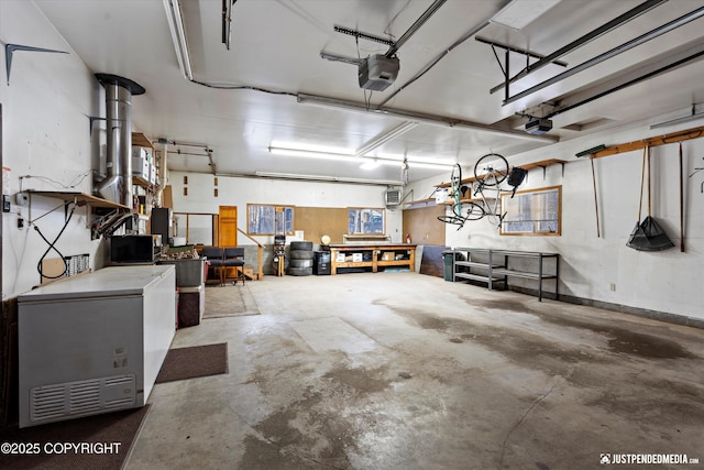 garage featuring fridge, a garage door opener, and a workshop area