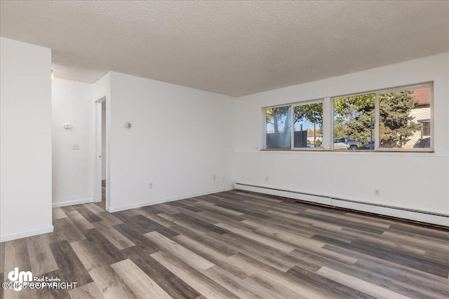 unfurnished room featuring dark wood-type flooring, baseboards, a textured ceiling, and baseboard heating