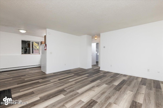 unfurnished room with dark wood finished floors, a textured ceiling, and baseboard heating