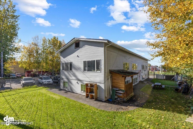 rear view of property with a lawn and fence