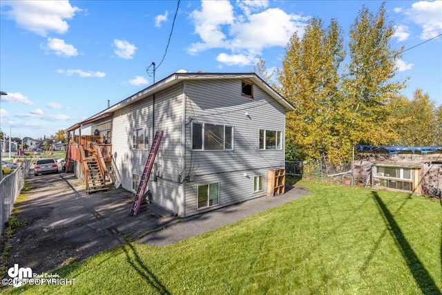 back of house with a yard, stairway, and fence