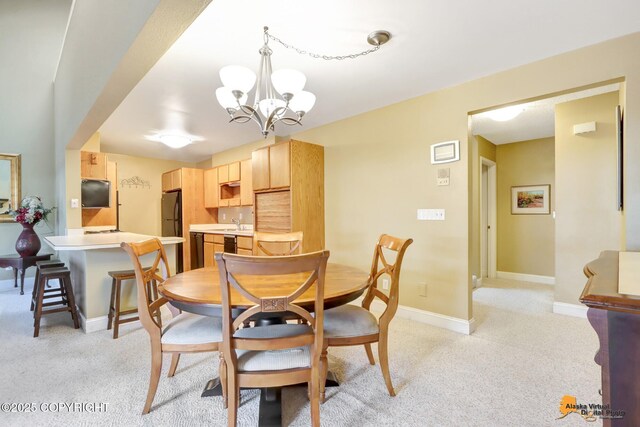 dining area featuring light carpet, a notable chandelier, and baseboards