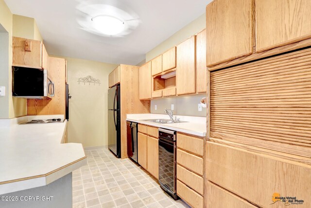 kitchen featuring light tile patterned floors, light countertops, appliances with stainless steel finishes, light brown cabinets, and a sink