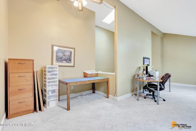 office featuring light carpet, ceiling fan, baseboards, and vaulted ceiling