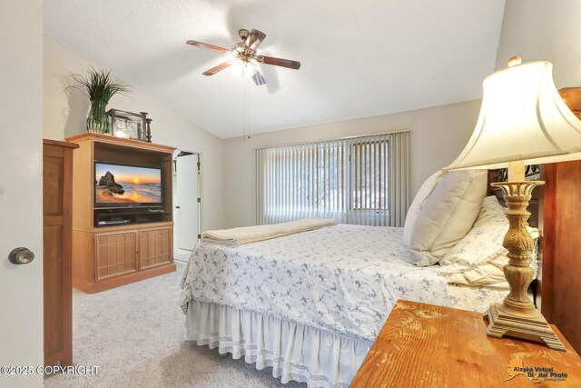 bedroom featuring light colored carpet, vaulted ceiling, and ceiling fan