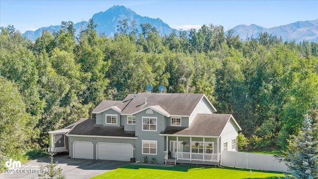 view of front of house with a mountain view, a garage, a front lawn, and covered porch