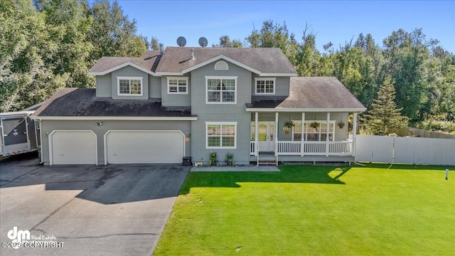 view of front of home with a garage, a front yard, and covered porch