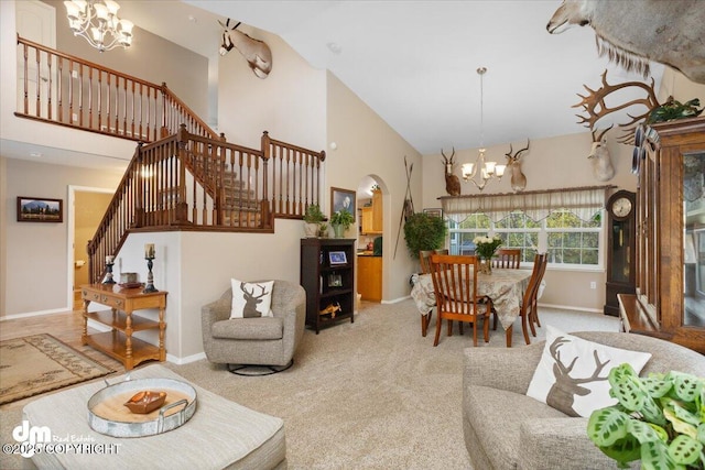 living room with light carpet, a notable chandelier, and high vaulted ceiling