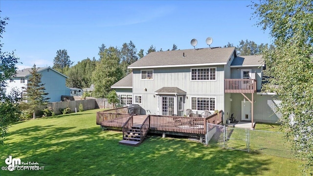 rear view of house with a deck and a lawn