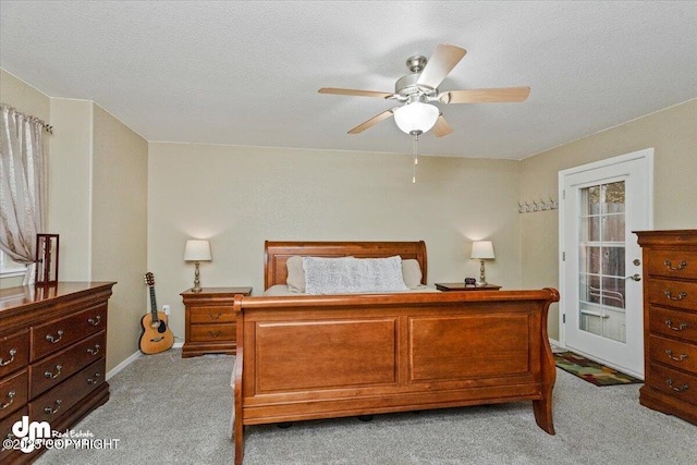 bedroom featuring ceiling fan, light carpet, and a textured ceiling