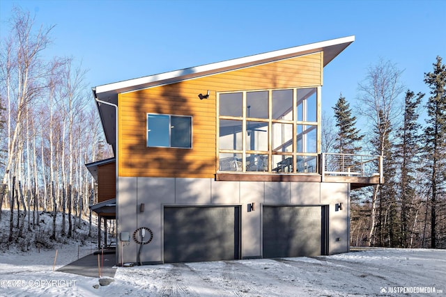 view of snow covered exterior featuring a garage