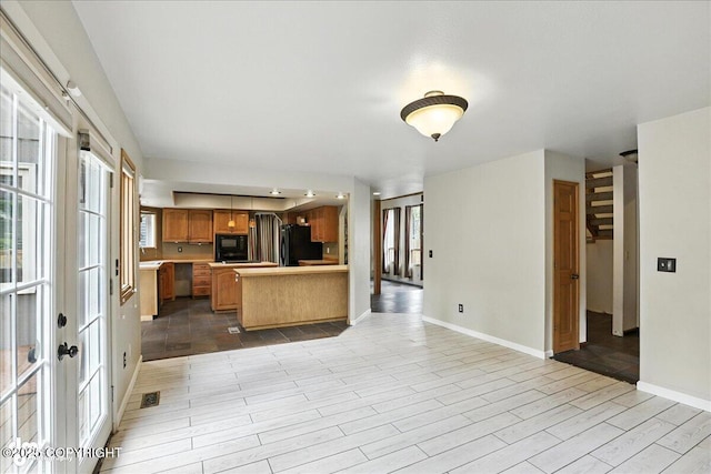 2629 Legacy Dr, Anchorage, AK 99516 - kitchen featuring black appliances, a peninsula, open floor plan, light countertops, and brown cabinetry