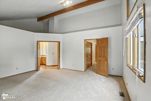 2629 Legacy Dr, Anchorage, AK 99516 - unfurnished bedroom featuring light carpet, beam ceiling, high vaulted ceiling, and ensuite bathroom