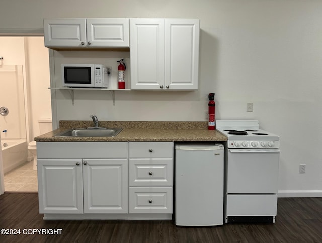 kitchen featuring white cabinetry, sink, white appliances, and dark hardwood / wood-style floors