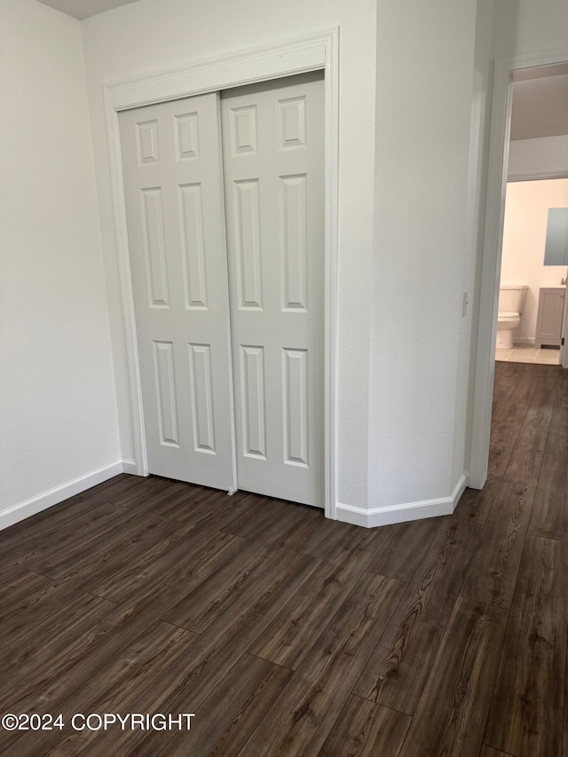 unfurnished bedroom featuring dark hardwood / wood-style floors and a closet