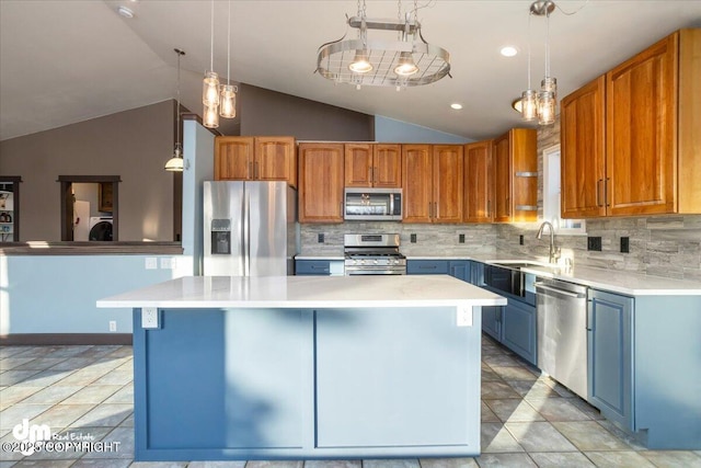 kitchen featuring appliances with stainless steel finishes, a center island, sink, and hanging light fixtures