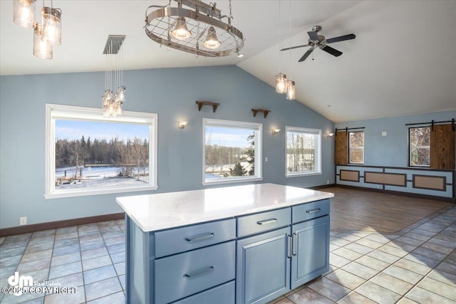 kitchen with decorative light fixtures, lofted ceiling, a center island, ceiling fan, and a barn door