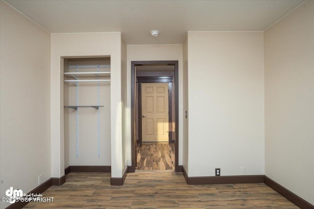 unfurnished bedroom featuring dark wood-type flooring and a closet