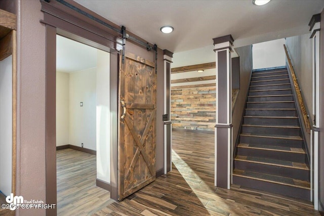 stairway featuring wood-type flooring and a barn door