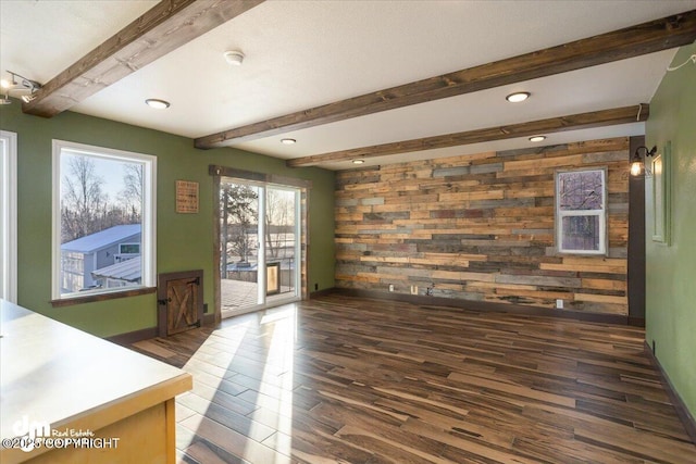 living room with dark wood-type flooring, beam ceiling, and wood walls