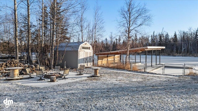 view of yard featuring a storage shed and an outdoor fire pit