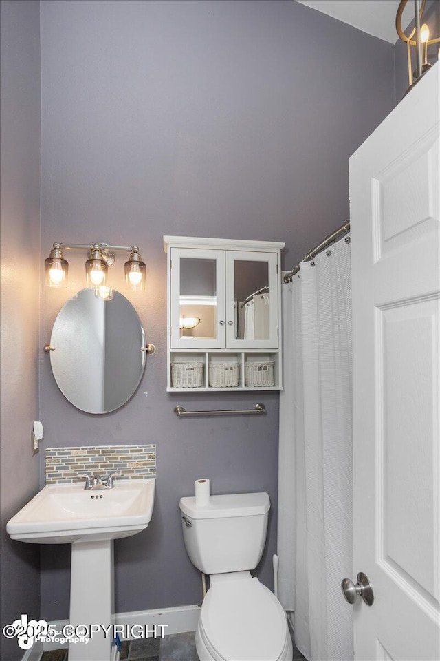 bathroom with a shower with curtain, backsplash, and toilet