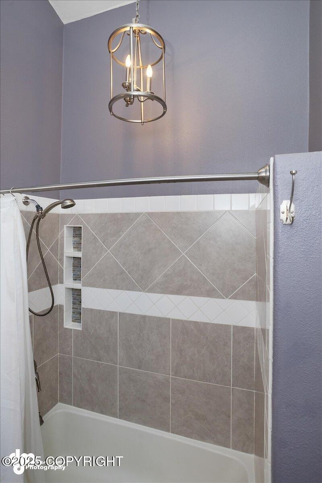 bathroom with shower / tub combo and a chandelier