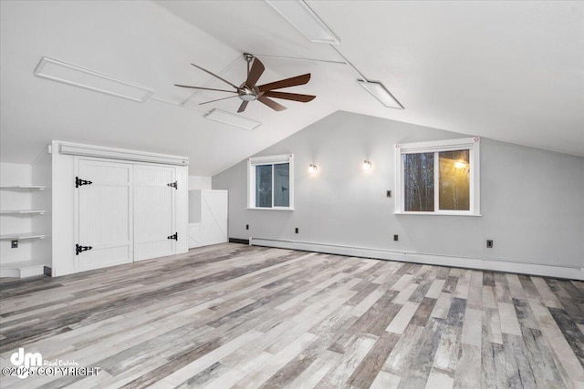 bonus room with lofted ceiling, a baseboard heating unit, light hardwood / wood-style flooring, and ceiling fan