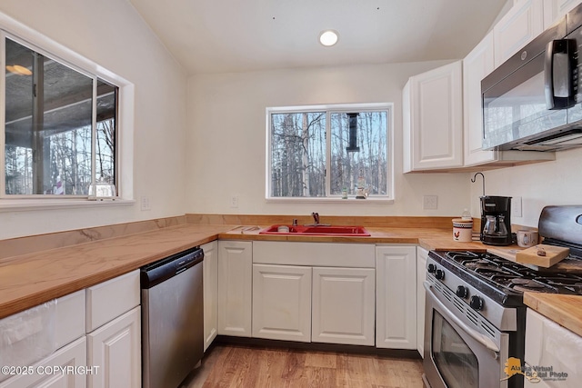 kitchen featuring wood counters, sink, white cabinets, and appliances with stainless steel finishes