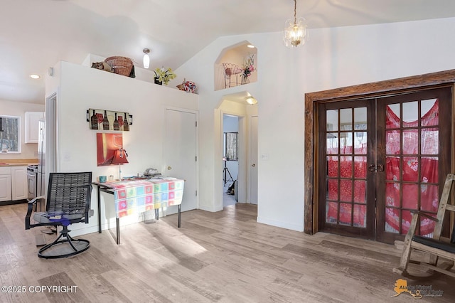 dining area with high vaulted ceiling, light wood-type flooring, and french doors