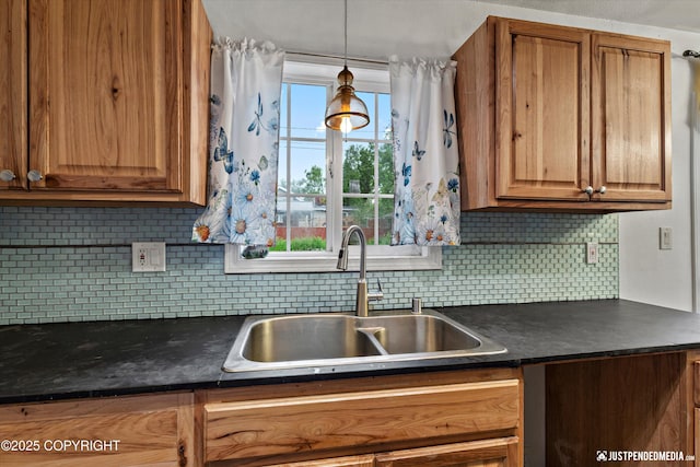 1510 E 40th Ct, Anchorage, AK 99508 - kitchen featuring dark countertops, decorative backsplash, brown cabinetry, and hanging light fixtures