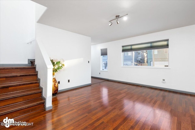 unfurnished living room with dark hardwood / wood-style flooring and a wealth of natural light